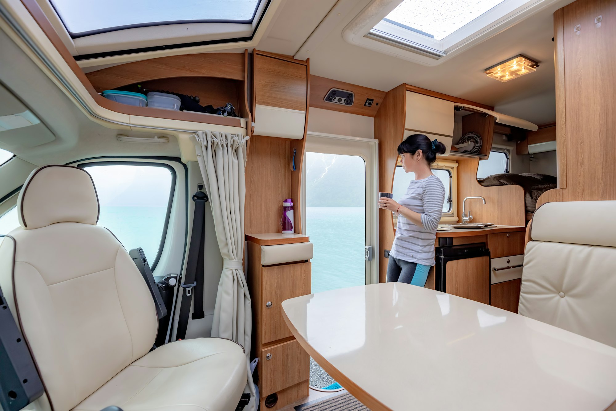 Woman in the interior of a camper RV motorhome with a cup of cof